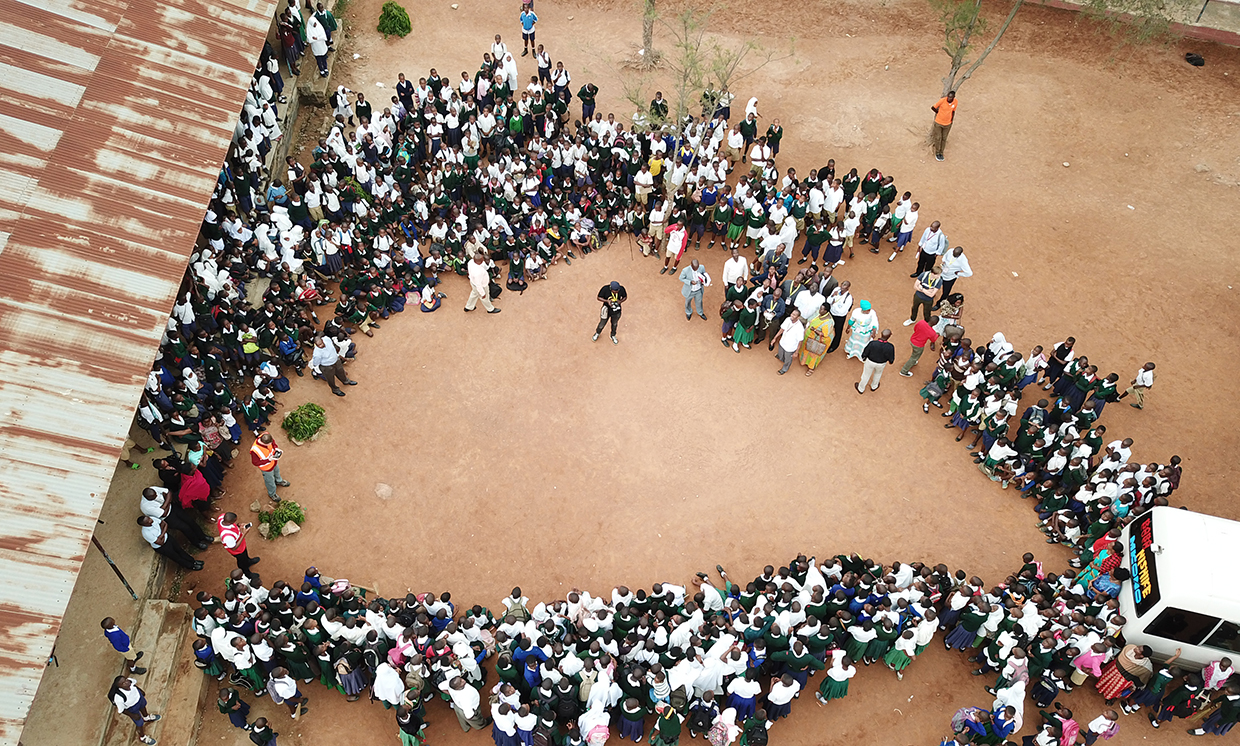 Aerial drone photo of a crowd of students listening to Tanzania Flying Labs' Leka Tingitana.