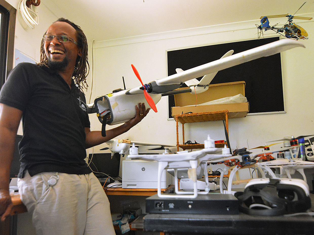 Freddie Mbuya showing drone parts in his workshop.