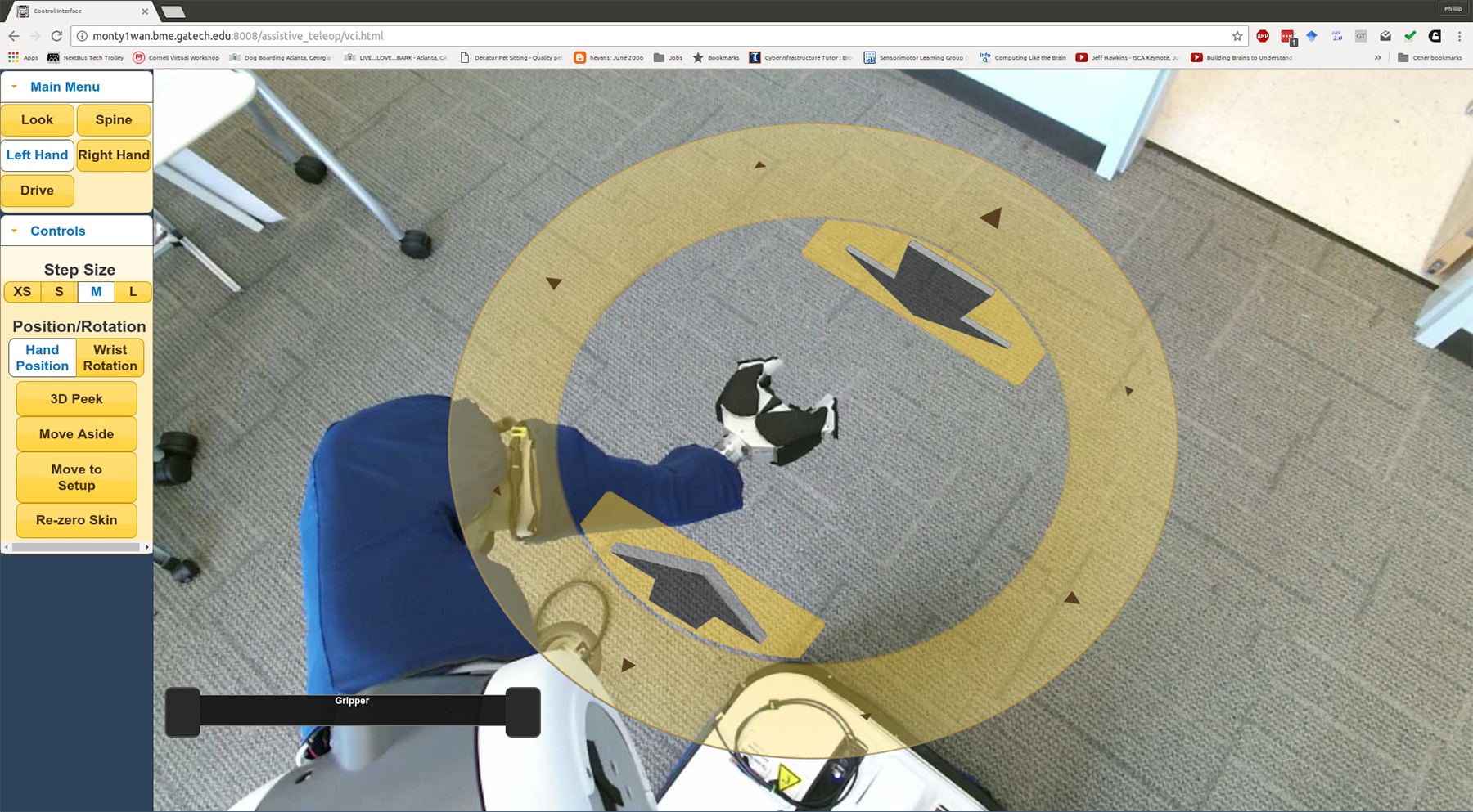 Image shows the view through the PR2’s cameras showing the environment around the robot. Clicking the yellow disc allows users the control the arm.